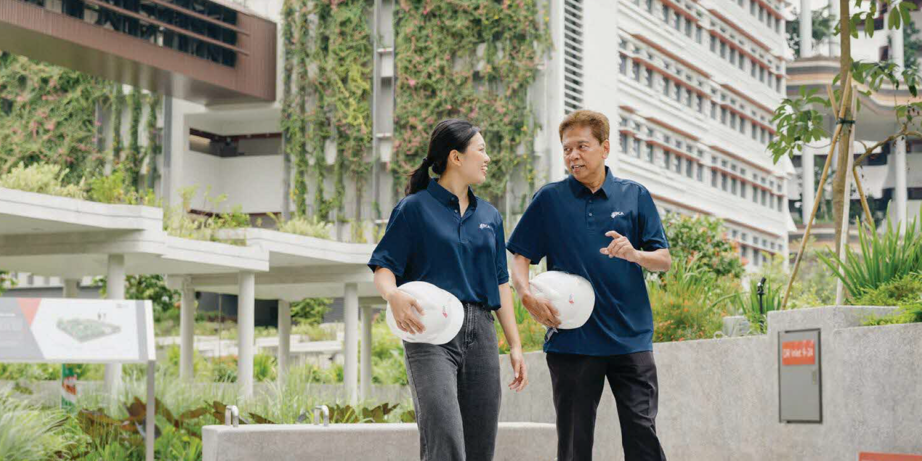 BCA officers walk through a green building, discussing sustainable design features.